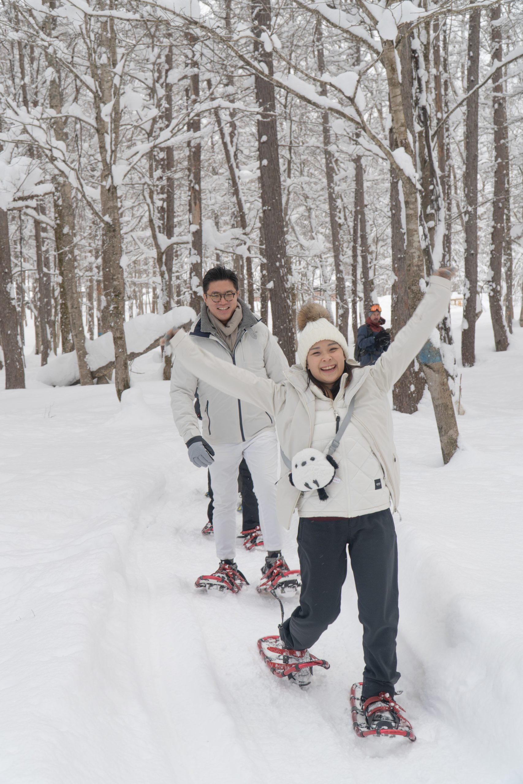 Couple celebrating on a snowshoe tour in a snowy Niseko forest