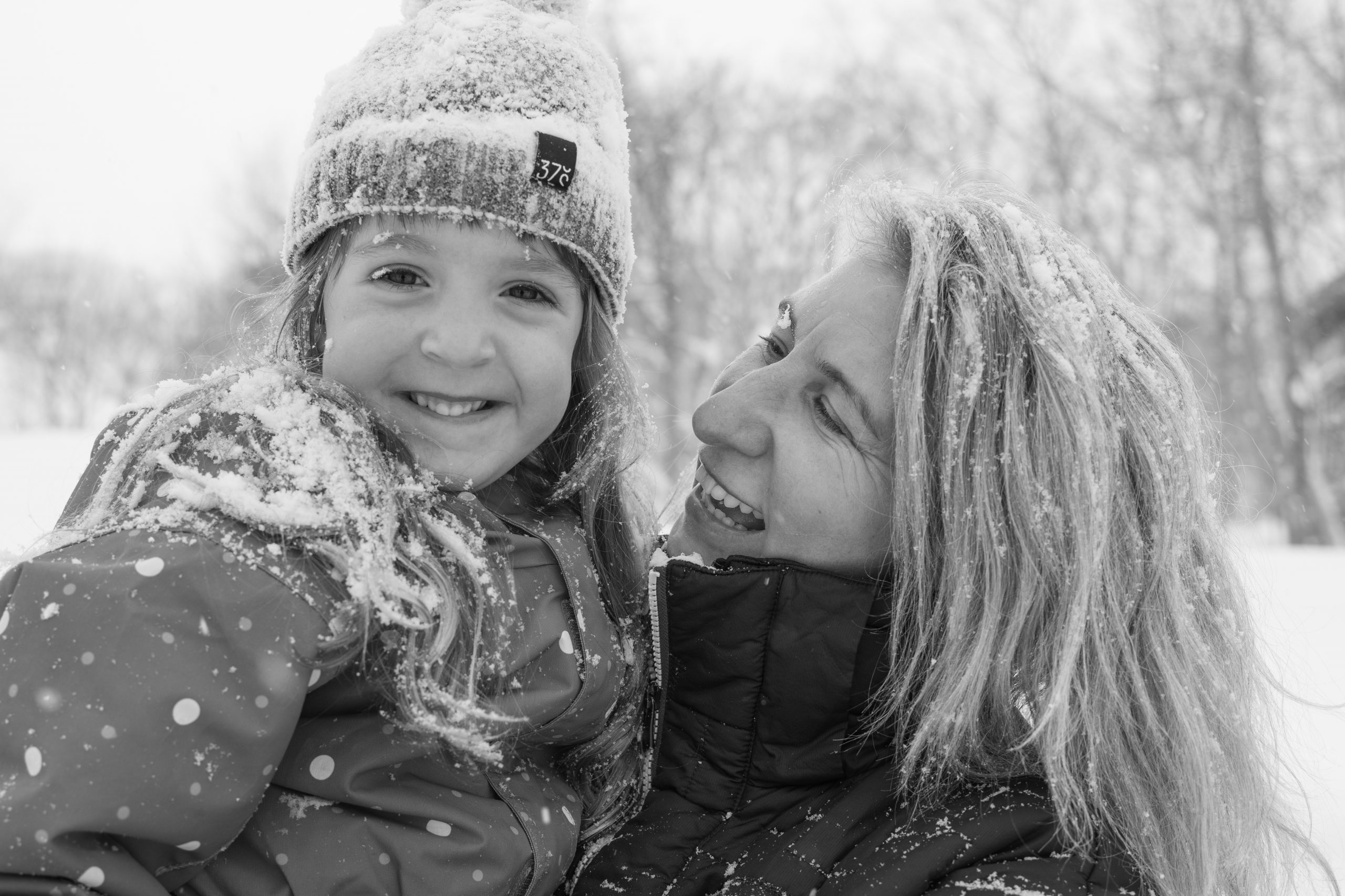 Black and white portrait of a mother and daughter in falling snow