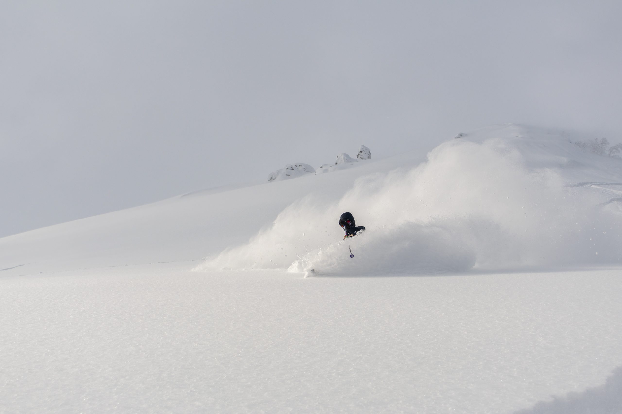 Backcountry skier dropping into deep Hokkaido powder