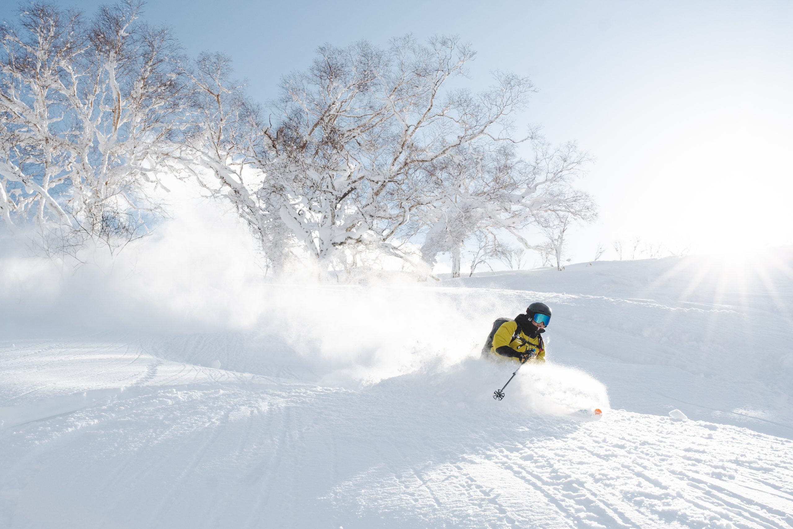 Skier dropping into untracked Niseko backcountry powder