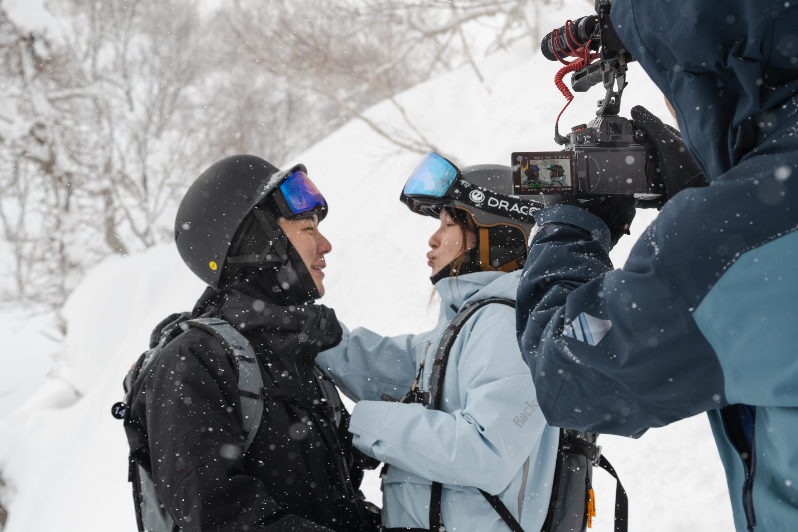 Videographer filming a couple moments after an on-mountain proposal