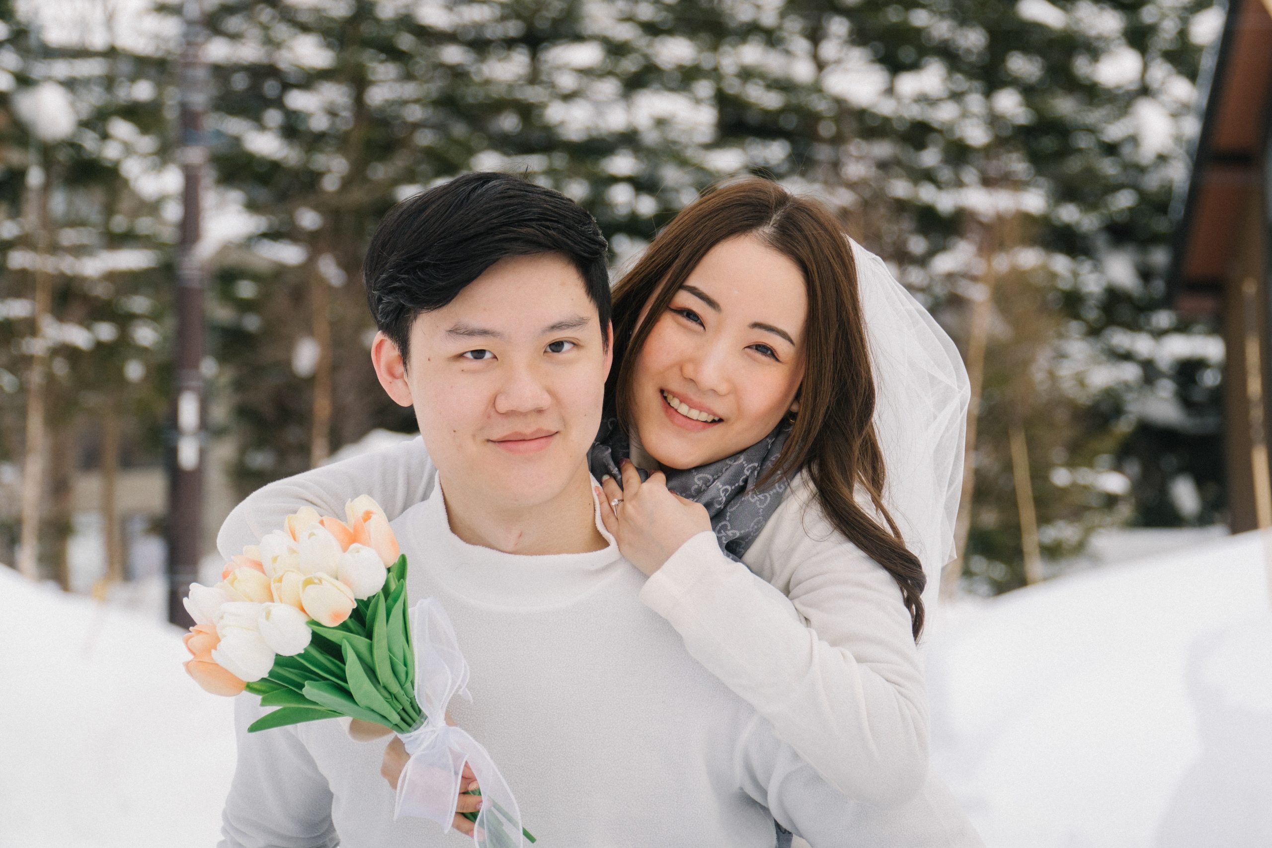 Couple holding a bouquet of tulips in the snow in Niseko